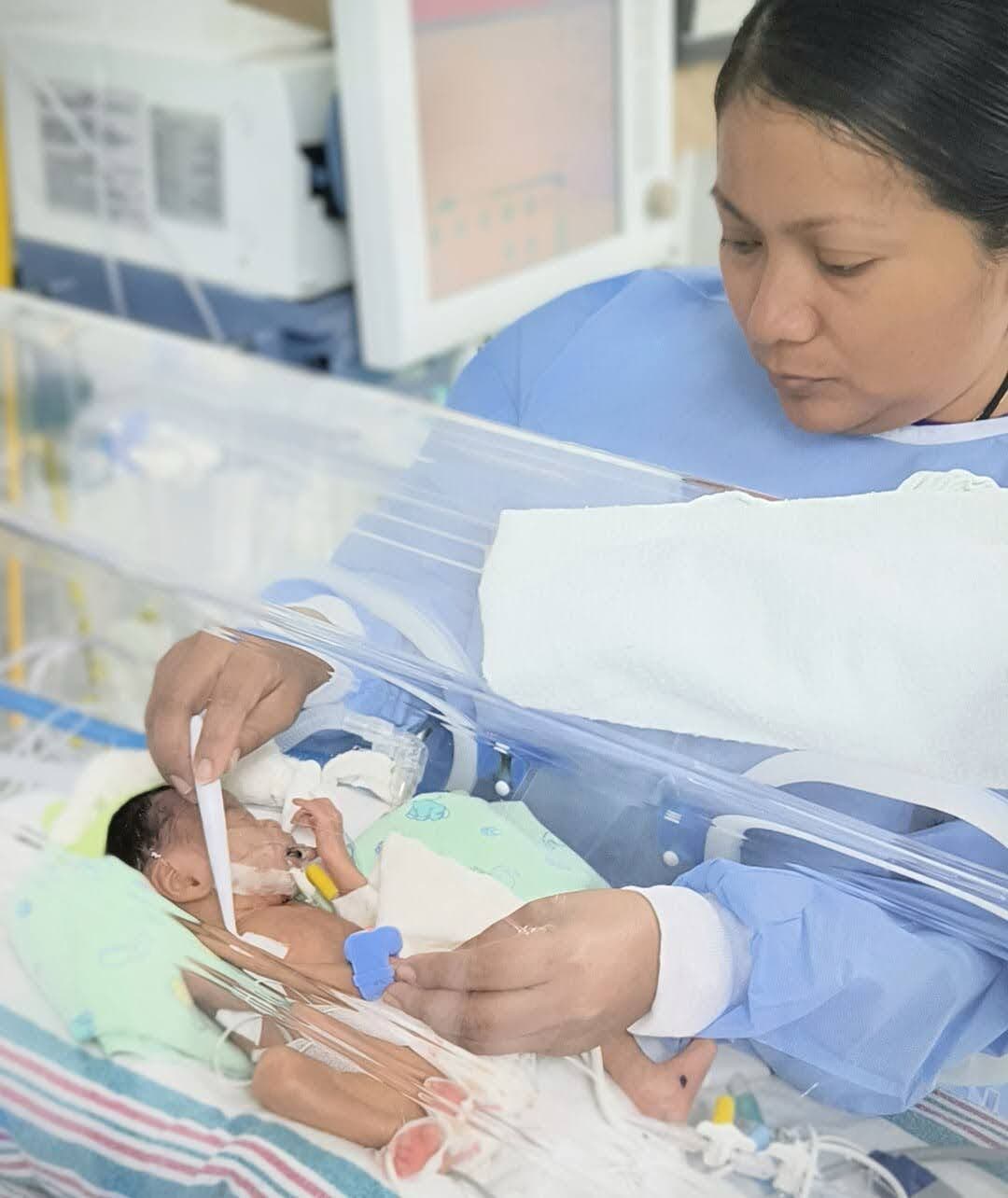 Nurse in Belize using BEMPU TempWatch to monitor baby temperature