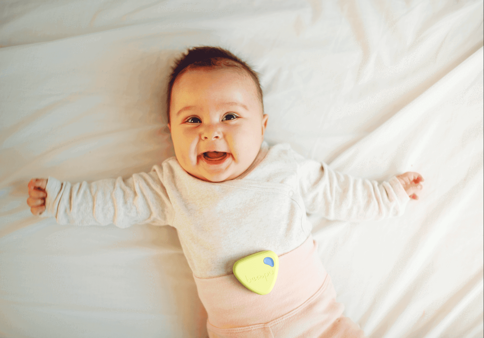 Smiling baby wearing the BEMPU BellyButton clipped above the belly button